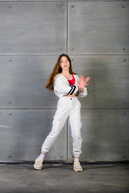 Mulher adolescente dançando hip-hop em um estúdio, roupas casuais