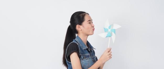 Mulher adolescente e brinquedos de moinho de vento de papel Retrato adolescente com roda de vento de papel de cor azul vara de madeira