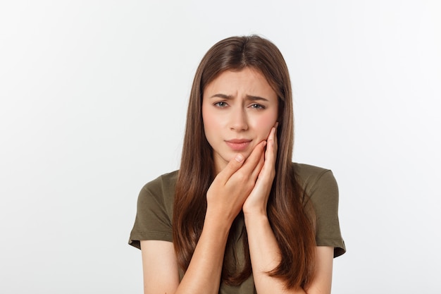 Mulher adolescente pressionando sua bochecha machucada com uma expressão dolorosa como se estivesse com uma terrível dor de dente