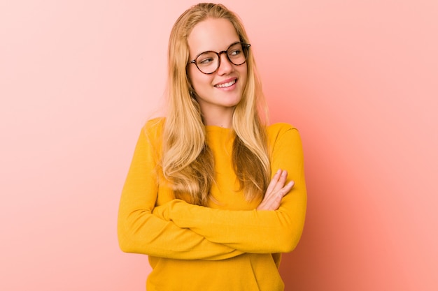 Mulher adorável adolescente sorrindo confiante com braços cruzados.