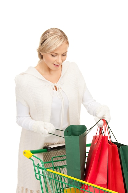 mulher adorável com carrinho de compras sobre branco