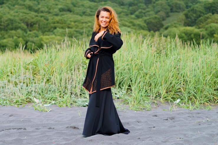 Foto mulher adulta alegre vestindo vestido preto na praia