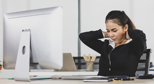 Foto mulher adulta asiática é escritório pessoas sentadas na mesa de trabalho no trabalho de escritório, ela tenta trabalhar duro dor no pescoço parece síndrome de escritório.