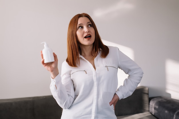 Mulher adulta chocada sorrindo e segurando o gel desinfetante