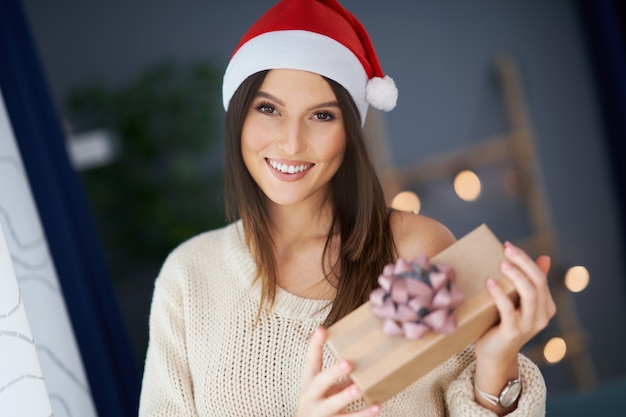 mulher adulta com presente de natal em casa