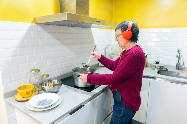 Mulher adulta cozinhando enquanto ouve música