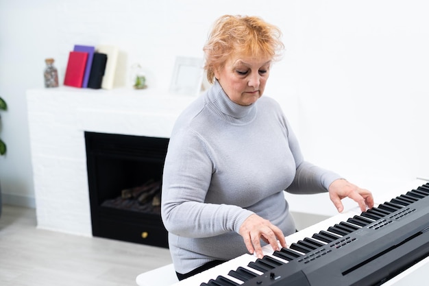 mulher adulta elegante tocando sintetizador.