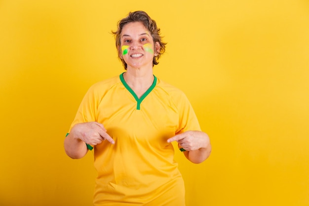 Mulher adulta fã de futebol do brasil apontando para o centro só aqui