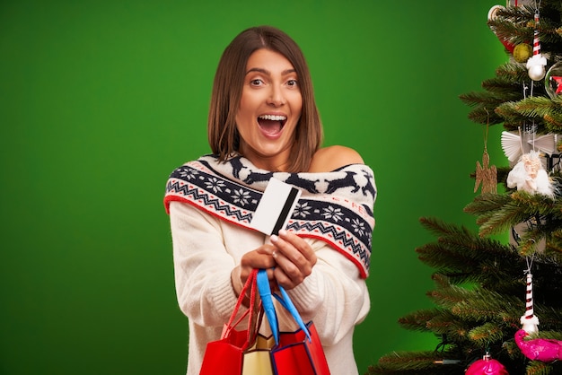 Mulher adulta feliz comprando presentes de Natal sobre fundo verde