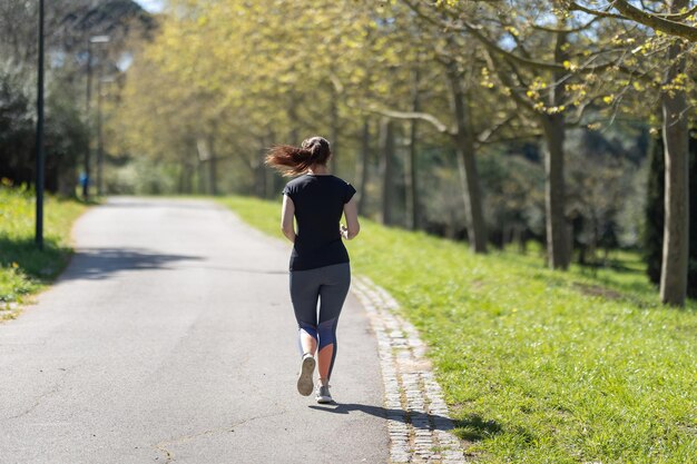 Mulher adulta fitness correndo no parque