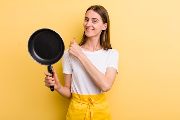 Mulher adulta jovem chef bonita com uma panela