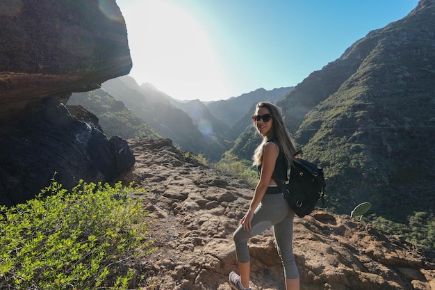 Mulher adulta jovem explorando um terreno montanhoso acidentado capturado em um quadro horizontal com um lado A