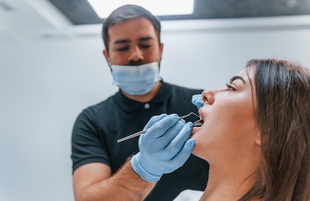 Mulher adulta jovem tem uma visita na clínica do dentista. Concepção de estomatologia.