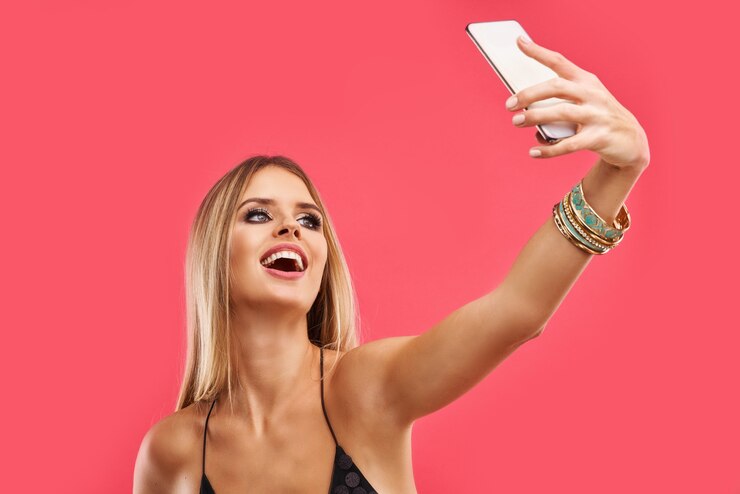 Foto mulher adulta linda loira posando rosa com smartphone