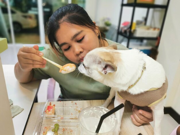 Mulher adulta média segurando um telefone celular na cozinha