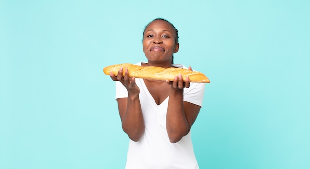 Mulher adulta negra afro-americana segurando uma baguete