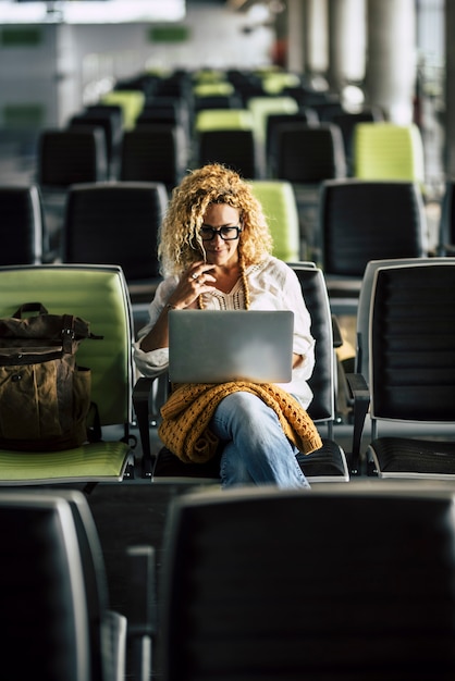 Foto mulher adulta sozinha esperando o voo no portão do aeroporto