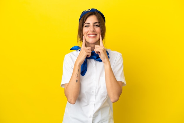 Mulher aeromoça isolada em fundo amarelo sorrindo com uma expressão feliz e agradável