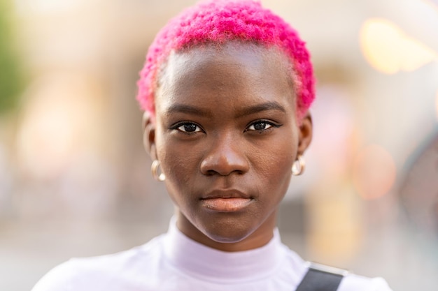 Mulher africana com cabelo rosa curto ao ar livre