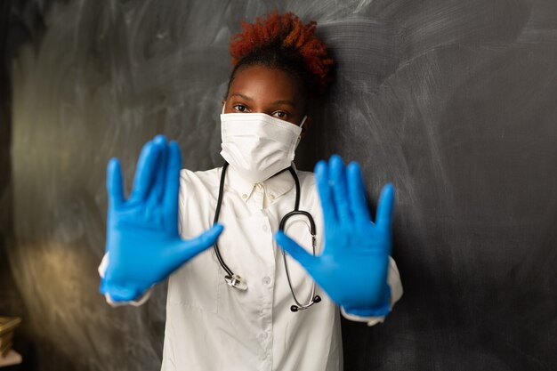 Mulher africana em uniforme médico com gesto de mão