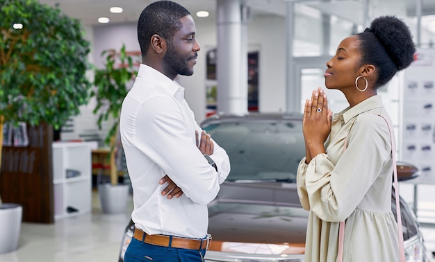 Mulher africana implorando ao marido no showroom de carros