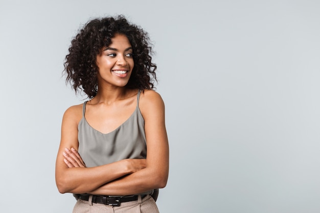 Mulher africana jovem feliz vestida de forma casual, isolada, de braços cruzados