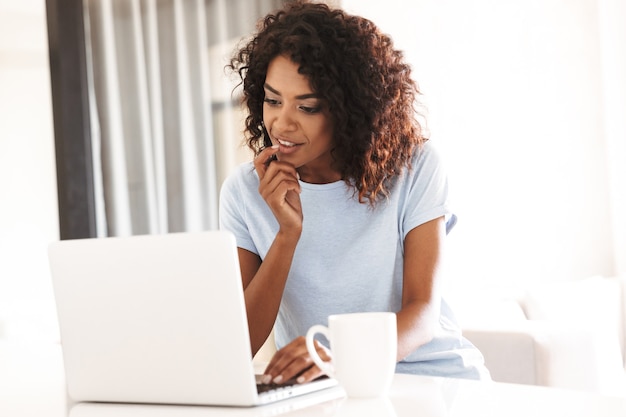 Mulher africana pensativa usando laptop