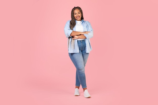 Mulher africana posando vestindo roupas plus size em fundo rosa