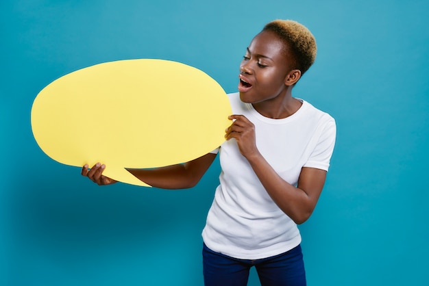 Mulher africana segurando o balão amarelo em forma de oval.