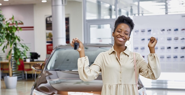 Mulher africana sorridente com as chaves de seu carro novo