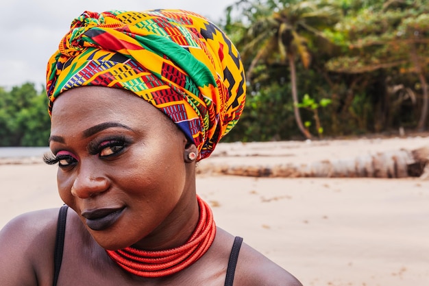 Foto mulher africana sorrindo para a câmera em uma praia tropical em axim, gana, áfrica ocidental