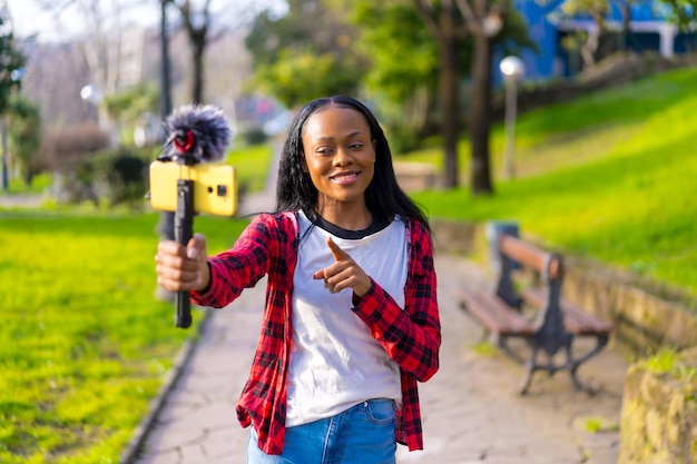 Mulher africana vlogging gravando um vídeo com celular ao ar livre