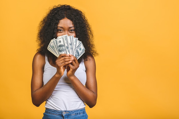 Mulher afro-americana bem-sucedida segurando muitas notas de dólar