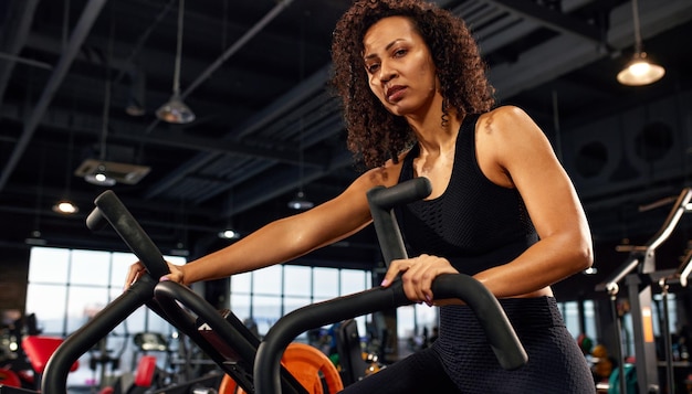 Mulher afro-americana cardio emagrecimento treinamento aeróbico em bicicleta