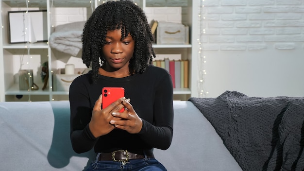Mulher afro-americana com cabelos cacheados em smartphone