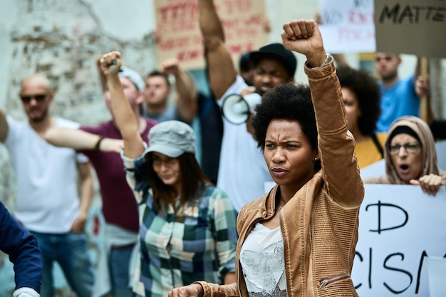 Mulher afro-americana com punho erguido participando de manifestações de direitos civis negros