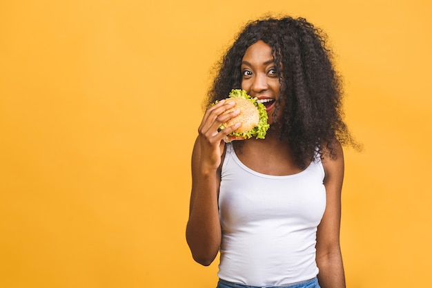 Mulher afro-americana comendo hambúrguer