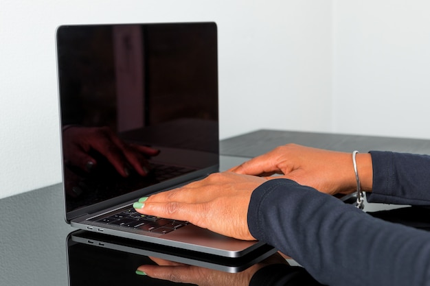 Mulher afro-americana digitando no teclado em um laptop moderno