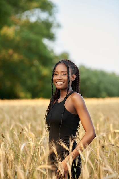 Foto mulher afro-americana em um campo de trigo.