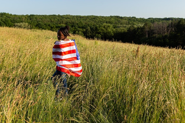 Mulher afro-americana envolta em bandeira americana