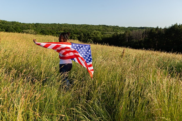 Mulher afro-americana envolta em bandeira americana