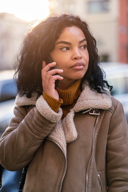 Foto mulher afro-americana falando ao telefone