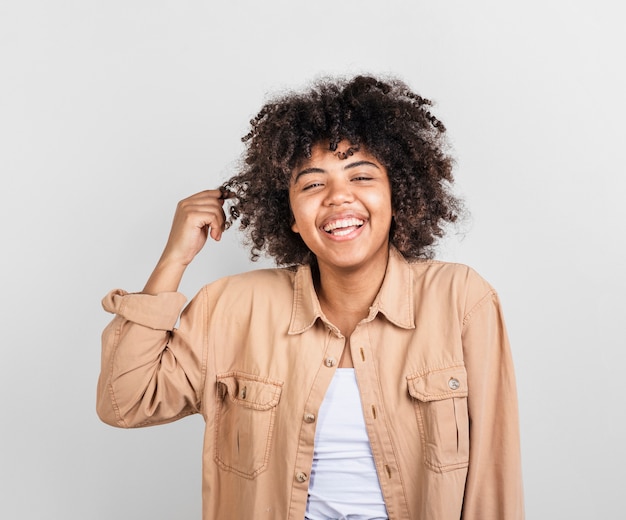 Mulher afro-americana feliz brincando com o cabelo dela