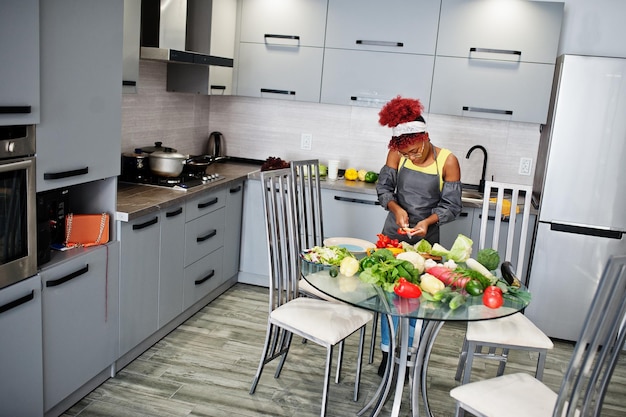 Mulher afro-americana filmando sua transmissão de blog sobre comida saudável na cozinha de casa