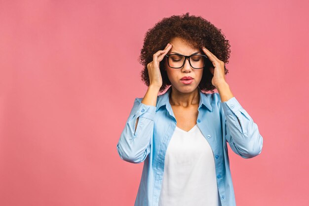 Mulher afro-americana nervosa respirando acalmando aliviando a dor de cabeça ou gerenciando o estresse isolado no fundo rosa