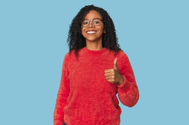 Mulher afro-americana no estúdio sorrindo e levantando o polegar