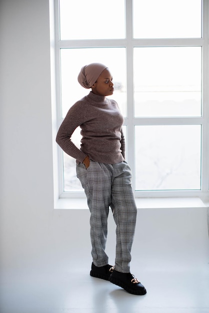 Mulher afro-americana olhando para a janela no estúdio
