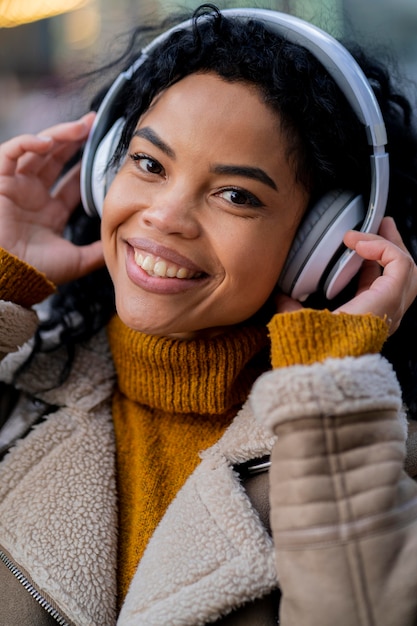 Foto mulher afro-americana ouvindo música em fones de ouvido