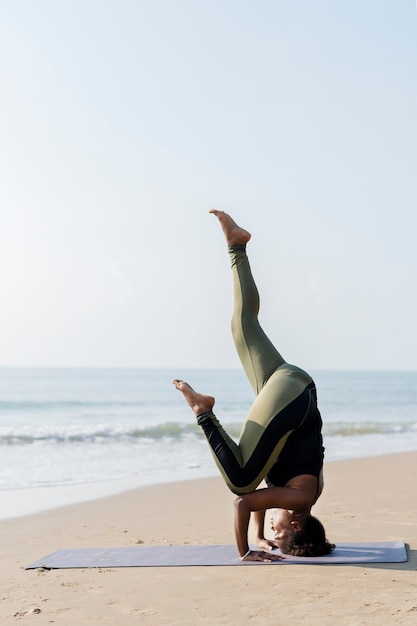 Foto mulher afro-americana praticando ioga na praia