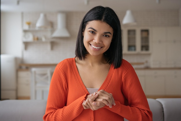 Mulher afro-americana sorridente tendo chamada de vídeo comunicação Freelancer online trabalhando em casa